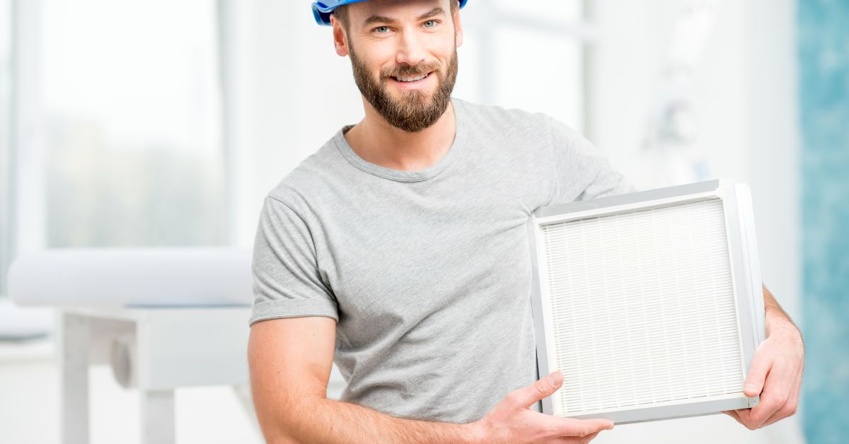 Mand står med et rent ventilationsfilter