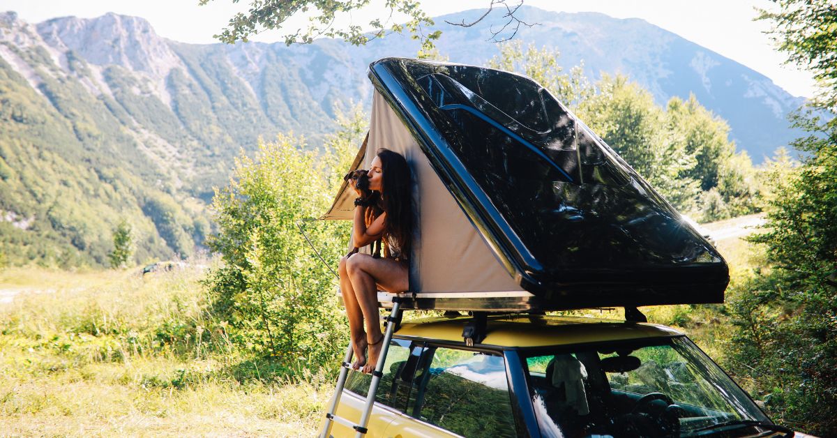 Kvinde sidder i et tagtelt til bil
